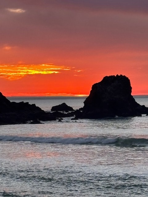 Orange sunset behind a sea stack on the Pacifica coast