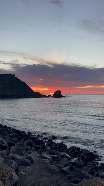 Vertical view of the rocky Pacifica shore at sunset